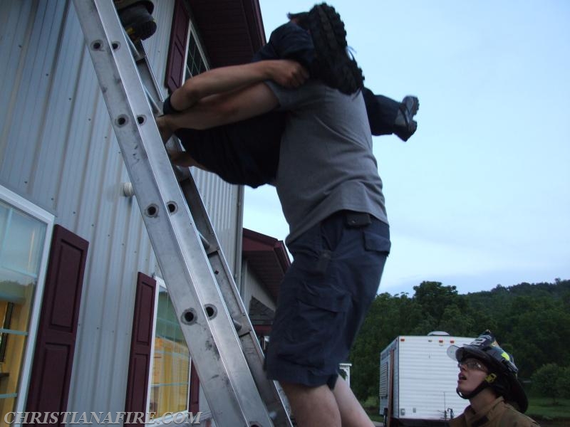 Assistant Chief Buckwalter demonstrating a way to bring a patient out of a second floor room and down a ladder.